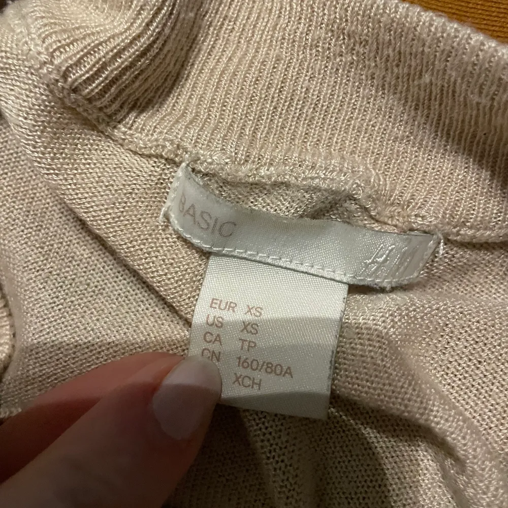 Beige stickad tunn tröja från H&M. Finns ett hål på högra axeln (se bild 2). Köparen står själv för frakten.. Stickat.