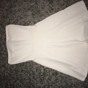 Vit klänning utan band - Fin klänning från hm som jag endast använt en gång på en skolavslutning. Det finns två små fläckar (kolla bild 2 och 3) men de syns knappast irl. Skulle säga att klänningen passar om man är 165 som längst. Storlek 32 men passar även 34. 