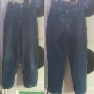Mom jeans från Gina tricot - Ett par högmidjade mot jeans från Gina tricot. Jeansen är i storlek 34 vilket motsvarar XS och sitter övanför ankeln på mig som är 1.69 lång. Jeansen är i bra skick och är inte urtvättade. Betalning sker via swish och fraktar spårbart som kostar 66kr! Hör av er vid funderingar eller vid intressen!