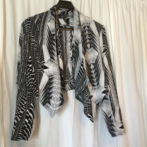 Kort blazer från H&M - Blazer i kortare modell med draperade detaljer. Något kortare baktill.