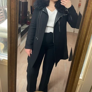 Kappa med päls från Zara - Säljer min svarta kappa med avtagbar päls från Zara i storlek S. Använd ett fåtal gånger och den köptes för 1495 kronor. Fin passform och med silvriga detaljer.