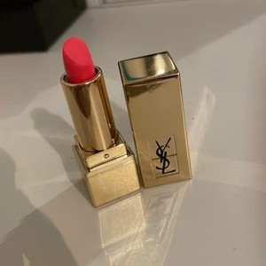 YSL läppstift med en söt smink låda  - Säljer nu denna söta mini YSL läppstiften som aldrig har använts, färgen är 52 (en  orange, rosa färg). Det kommer även med en söt liten låda för att kunna bevara läppstiften i. Lådan är väldig effektiv och man kan t.ex använda den för att ha smink saker när man ska åka utomlands för den är ganska liten men få plats med mer än vad man tror. Dessutom finns det också en liten spegel i lådan! Kontakta mig för fler frågor/ bild. Ops köparen står för frakten!!!💖💕