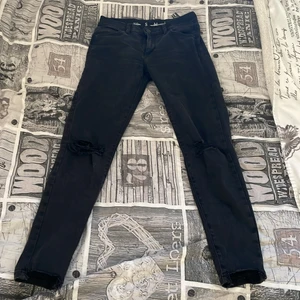 Svarta jeans med hål vid knäna  - Alldeles för små byxor för midjan de är stl S 
