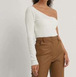 Topp med en arm NA-KD  - En vit ribbadtopp från NA-KD med en arm. Använd fåtal gånger, säljer på grund av kommer inte till användning. Storlek Medium, pris 150kr exklusive frakt 