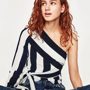 One Shoulder Top - One shoulder Top från Zara Trafaluc, använd men i bra skick. Band som man knyter i sidan, men kan stylas på flera sätt. Relativt liten i storleken men passar xs-s, frakt tillkommer