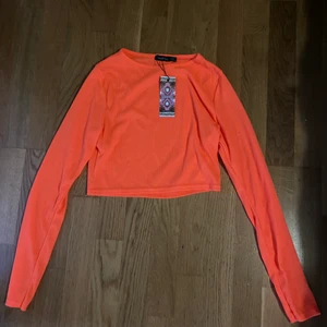 Neon tröja. - En orange/rosa neon tröja. Perfekt om du ska på neon fest tex. Aldrig använd så prislappen är kvar. Passar mig som är xs/s