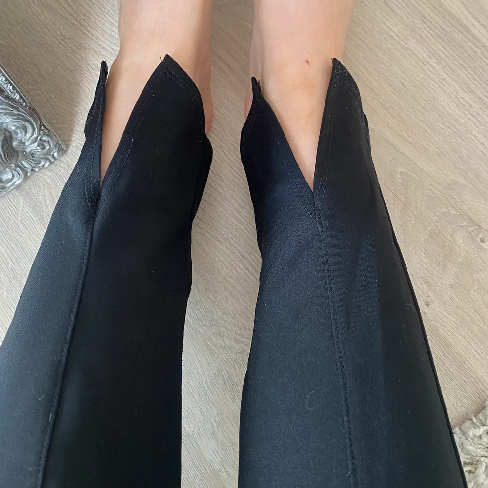 Svarta byxor med slits i vanligt tyg med en söm i bitten av benet. Från nelly ursprungligen i storlek M. Finns en skrap skada på knät vilket inte syns på bilderna men självklart kan jag skicka bild på den också.. Jeans & Byxor.