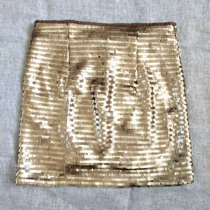 H&M guld kjol - Guld mini kjol med paljetter och foder. Dragkedja i sidan.