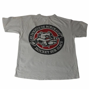 Les Douges De Bordeaux - Vintage Tee  - En riktigt fet vit/beige tröja som har ett coolt tryck på ryggen samt på bröstet. Med lite blekta röda och blå tröja. Perfekt för en baggy outfit med ljusa färger som passar till varma dagar! Köpt på en thriftstore i Frankrike. 