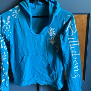 Billabong  - Luvtröja i tunnare tyg typ T-shirt material. Trycket är ngt spruckit, se bild 2.  Står ej storlek i utan uppskattar till s/m. Köpare betalar frakt 