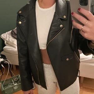 Skinnjacka - Svart skinnjacka med gulddetaljer. Bandet till jackan saknas annars är den i jättefint skick! Frakt tillkommer! 