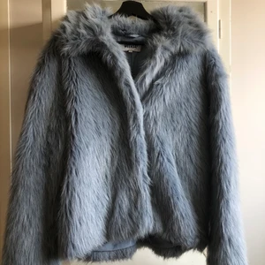 FurryJacket från Weekday - Säljer dena fina blåa fake-päls från Weekday! Inköpt för ca 2 år sedan och har inte används mer än några gånger! Det är i fint skick och har inga defekter. Man knäpper igen den med hjälp av tre klipps som gömmer sig under pälsen! Den är i storlek small men är enligt mig oversized! Är normalt en medium när det kommer till jackor!💙