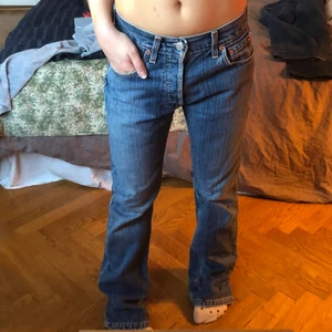 Lågmidjade Levis Jeans - Lågmidjade jeans ifrån levis i storlek W:28 L:32, aningen stora på mig som oftast har storlek 26. Jag är 158cm lång. Midjemåttet är 36cm (mätt rakt över) och innerbenslängden är 80cm. Aningen slitna där nere men inget man tänker på. Säljer direkt för 300kr och fri frakt. 