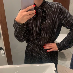 Klänning - Superfin klänning med knäppning och knyte i halsen, små vita stjärnor på tyget, lite genomskinlig och väldigt snygg över jeans med ett bälte i midjan eller som klänning med stövlar till! 