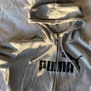 Puma Zip up hoodie - * Äkta Puma  * Inköpt: Mars 2021 Röda korset  * Använd: en del * Storlek: large / 44 (uppfattar själv som x-small)  * Luva med tråd  * Kvalitet: väldigt bra, mjuk 