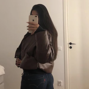 Jacka  - Kort brun jacka i skinn material. Varm och skön, perfekt för hösten!! Endast använd 2 gånger.