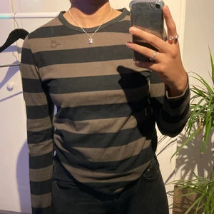 Svart och grön randig långärmad tröja - En långärmad randig tröja, väldigt snygg. Köpte den secondhand men har aldrig använt själv:) Den är i storlek M men känns mer som en S.