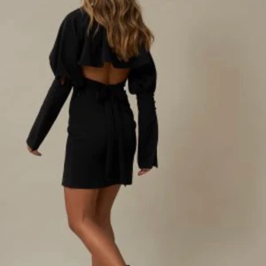 Svart klänning  - En kort svart klännig med en lite slit och öppet i ryggen. Den perfekta klänning för jul eller nyår 🥂 från HANNA SCHÖNBERG x NAKD. helt oanvänd med lappen kvar. Frakt tillkommer 