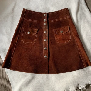 Vintage kjol i mocka  - Vintage kjol i mocka liknande tyg. Denna kjol var min mormors och är därför från 70-talet. Sitter riktigt bra vid midjan och framhäver en fin form i det området. Den är dessutom varm och skön och är fortfarande i riktigt bra kvalite. 