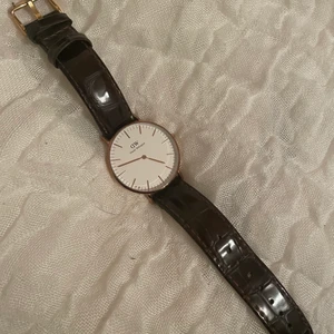 Klocka Daniel Wellington  - Väldigt fin klocka från Daniel Wellington. Använd men sparsamt använd och fortfarande väldigt fräsch. Stiligt brunt läderarmband🌸