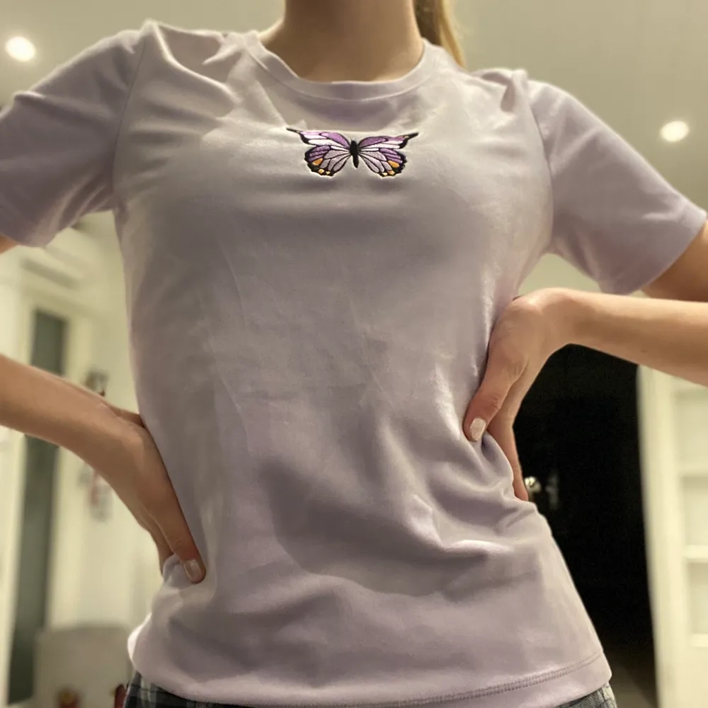 En lila färgad tröja med en ditt syd fjäril 🦋 . T-shirts.