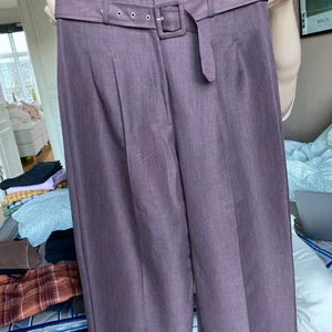 Lila kostymbyxor med skärp - Coola nya kostymbyxor i mörklila, aldrig använda! Höga i midjan med skärp och vida ben. 