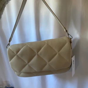 Beige väska från ginatricot  - En beige helt oanvänd väska från ginatricot. Det finns även ett längre band som följer med. Säljer för 200 + frakt 66❤️