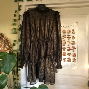 festlig klänning  - Festlig volang klänning mönstrad i svart och brons/guld. Köparen står för frakten❣️