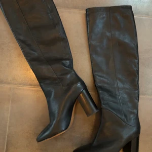& Other Stories stövlar - Säljer dessa supersnygga Chrome Free Tanned Leather Knee High Boots från & Other Stories pga köp av fel storlek. Använda endast en gång så de är i utmärkt skick förutom slitningar på yttersulan. Köpta för 2950 kr.