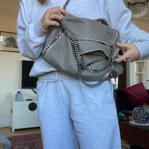 Stella McCartney väska  - Säljer min Stella McCartney väska i grått. Bra skick, litet litet märke men det syns knappt. Sparsamt använd. Dustbagen ingår 