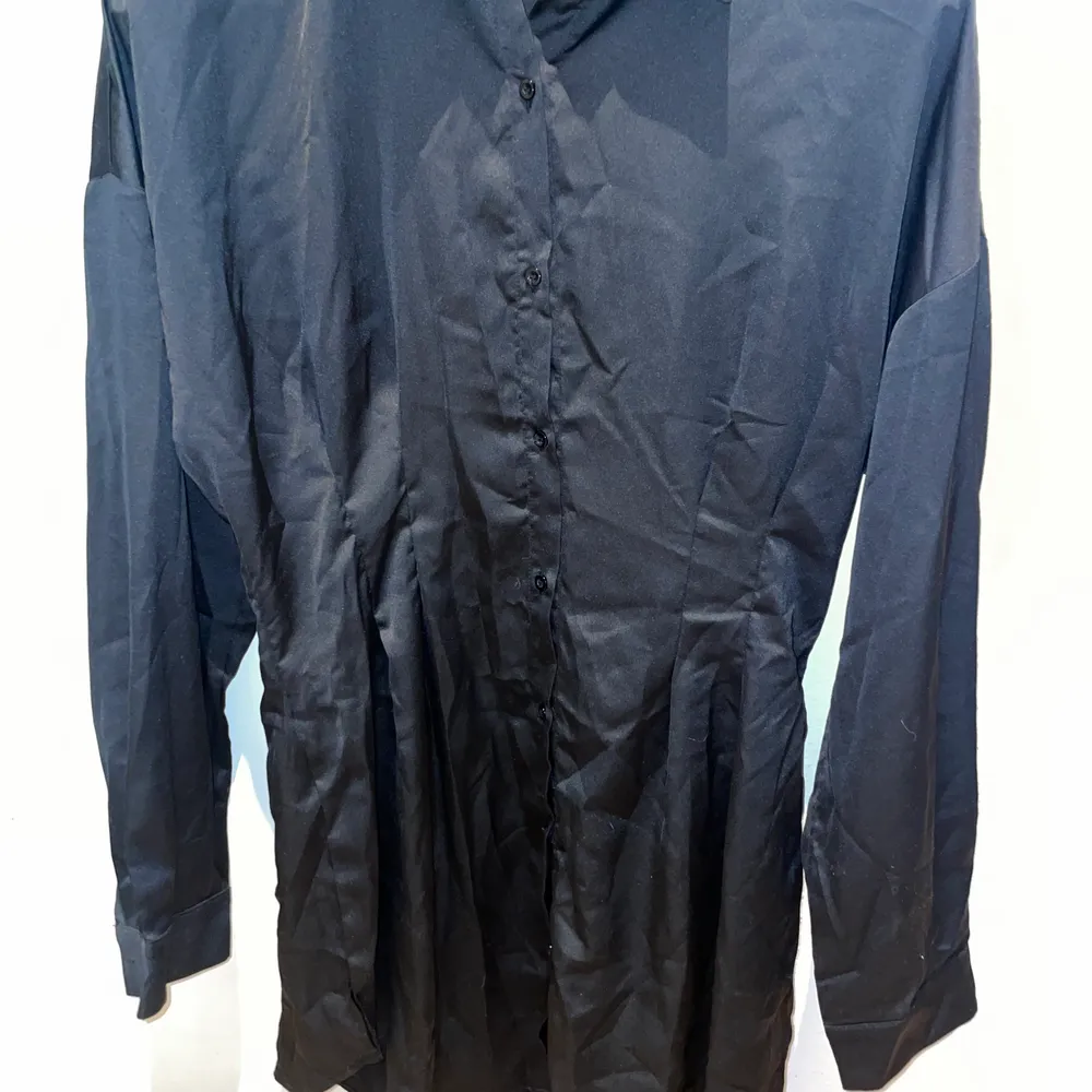 Skjortklänning i satin silke som är tightare i midjan och markerar. Aldrig använd. Kort så kan även användas som vanlig skjorta. Klänningar.