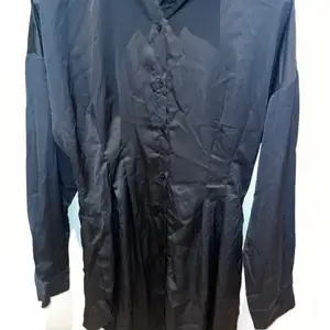 Skjortklänning i satin silke som är tightare i midjan och markerar. Aldrig använd. Kort så kan även användas som vanlig skjorta