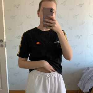 Ellesse tshirt - Jättecool något kroppad tshirt. Gul på ärmarna och två patches på brösten:) skriv om du har frågor
