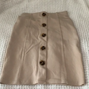 Beige Kjol - Knappar fram och strechsig, sitter väldigt fint på!