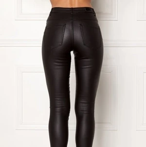 Svarta läderimmitation byxor strl M - Svarta coated byxor i läderimmitation. Använda fåtal gånger så i fint skick utan skador eller fläckar. Hög midja. Smala byxben. Köparen står för fraktkostnad på 60kr.