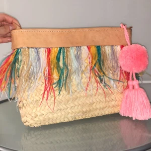 Clutch/necessär  - Säljer en clutch/necessär med fina färg glada fjädrar och en tassel. 