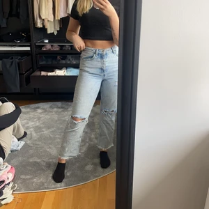 blå mom jeans med slitningar - Snygga blå mom jeans med slitningar längst ned, lite korta i modellen, endast använda 2 gånger då jag har flera liknade jeans. superfina på sommaren med en vit topp till