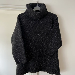 Glittrig stickad tröja  - Svart glittrig stickad tröja med trekvartslång ärm, så din passform! Ej stickig, super skön och perfekt för sommarkvällar. Den är köpt på second hand, är i fint skick