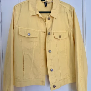 Somrig jeansjacka - Gul och somrig jeansjacka, perfekt att ha över en klänning eller till ett par jeans. Storlek M, men passar mig som har S. Lite kort i modellen. Nyskick, aldrig använd. Köpt för ca 300kr.