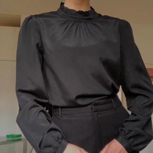 Svart blus - Svart blus i silkesmaterial från Gina tricot. Lös passform med hög krage och lite puff ärmar. Passar allt från XS-M beroende på om man vill ha den lite tightare eller flowy. Säljer för 50kr + eventuell frakt ☺️