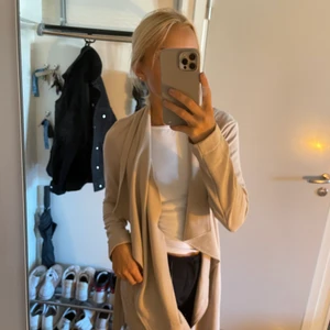 Kappa - Jag säljer min beiga kappa från Only, mycket fint skick, den är tunn med band man kan knyta runt midjan. Passar perfekt till sommar och vår, eventuellt i början på hösten också!