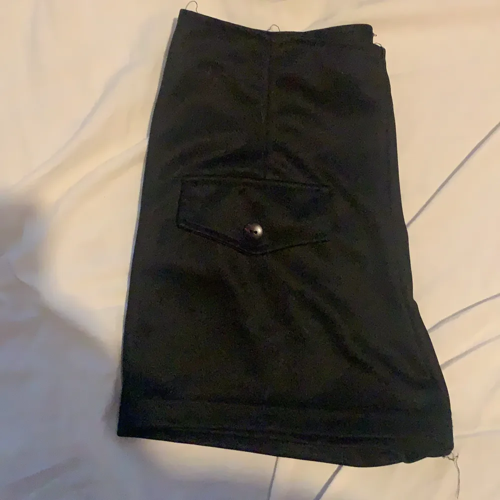 Svarta shorts med fickor där fram och en dragkedja på sidan . Shorts.