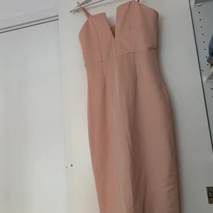 ”Smutsrosa” klänning  - Figursydd klänning med lite häftigare detalj vid bysten. Dragkedja bak, något skimrig.