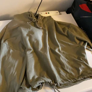 Militärgrön hoodie - Snören nere i midjan o uppe. 