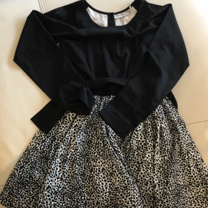 Klänning  - Elegant och festlig klämma som passar perfekt till festligheter. Denna klänning kommer med ett band som man kan knyta en större rosett vid midjan.