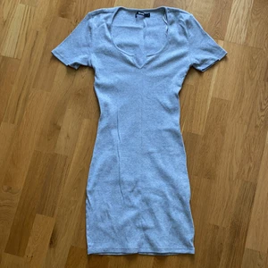 Grå klänning från Bikbok strl S - Grå klänning från Bikbok i storlek S. Använd endast två gånger och är köpt nyligen. Den kommer ner lite ovanför knäna på mig som är ca 163-165 cm