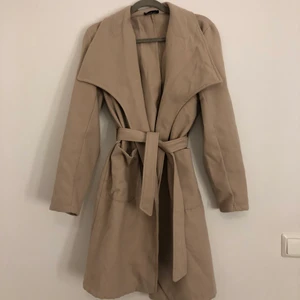 En Beige kappa - En fin oanvänd beige kappa som är lite stor för mig. Pris kan diskuteras