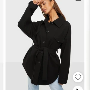 Kappa - Svart kappa från Nelly , med ett bälte man kan knyta i ryggen eller runt midjan , går även att ta bort bältet. I nyskick köpt i vintras , inga skador. 🤍 nypris 699