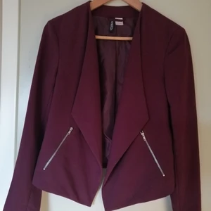 Vinröd kavaj - Vinröd kort kavaj med dragkedjor på fickorna. I storlek 38 men skulle säga 36-38. I fint skick!