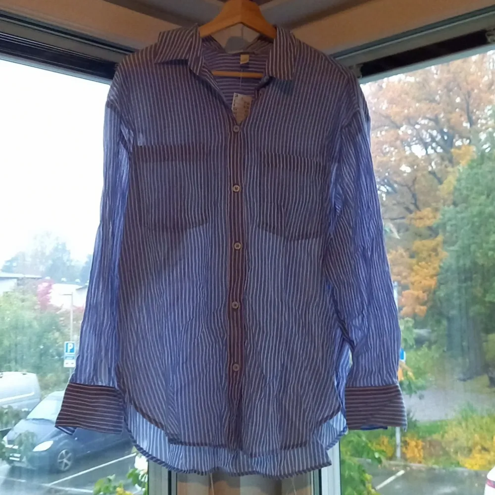 En luftig blå/vit randig skjorta ifrån H&M. Oanvänd med prislapp kvar. Säljer eftersom jag köpte fel storlek.. Skjortor.